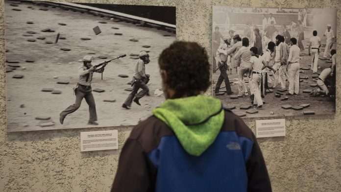 una-persona-observa-las-fotos-de-la-exposicion-con Una persona observa las fotos de la exposición con motivo del 40 aniversario de la muerte de Germán Rodríguez en los sucesos del 8 de julio de 1978.